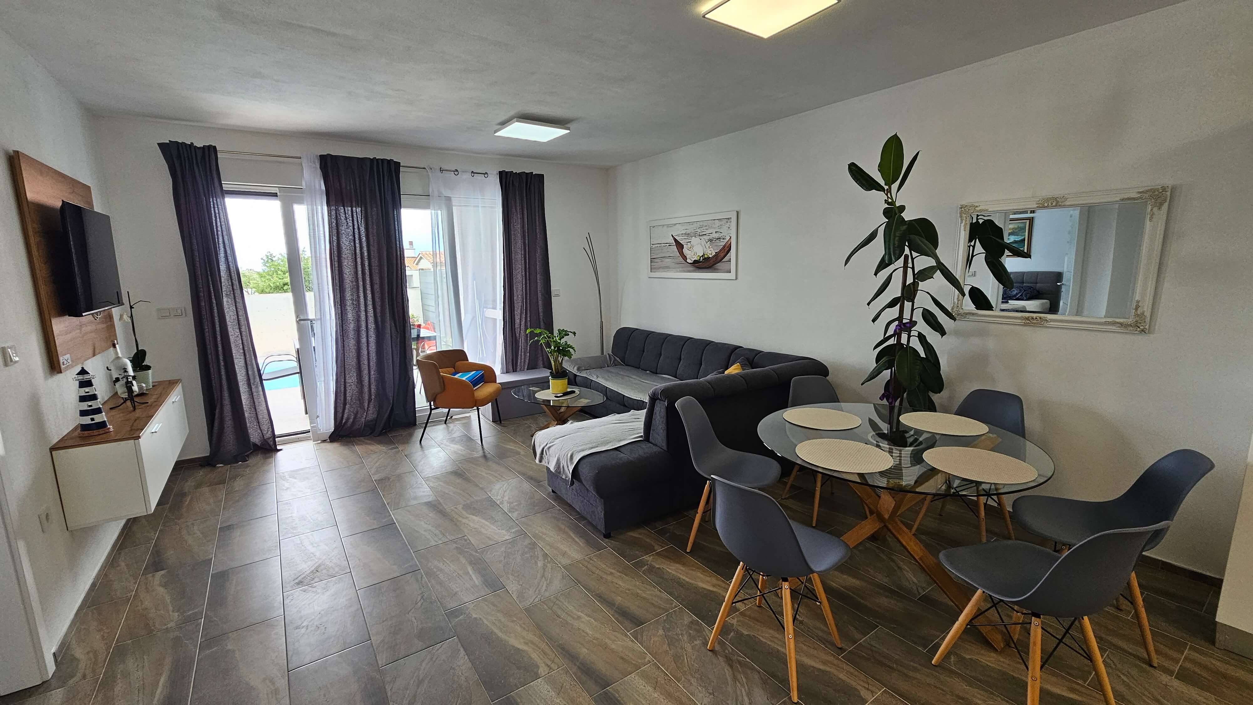 Dnevni boravak s blagovaonskim stolom, šest stolica i kaučem