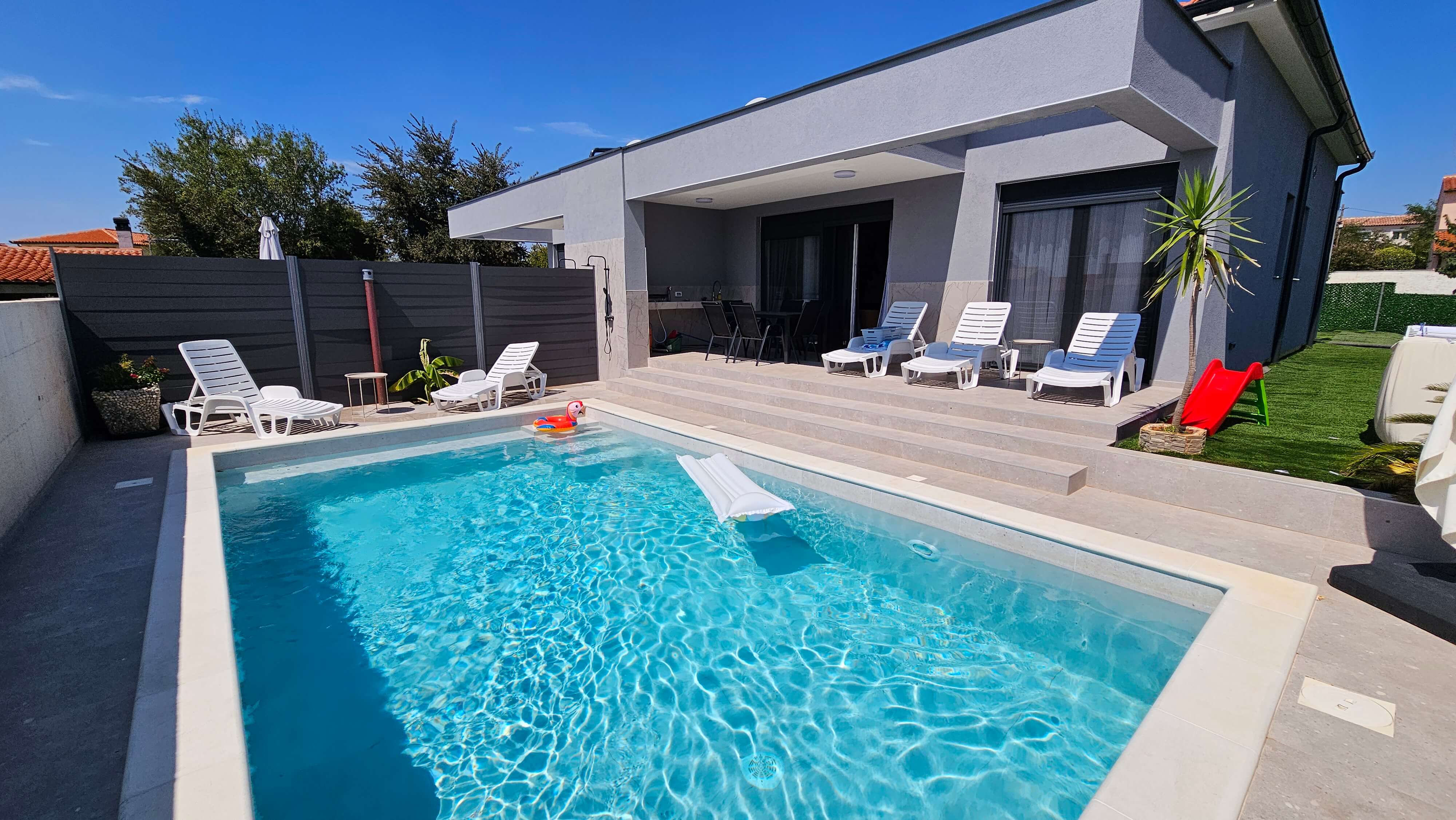 Pogled na bazen i kuću s vanjske terase u Vili Mia